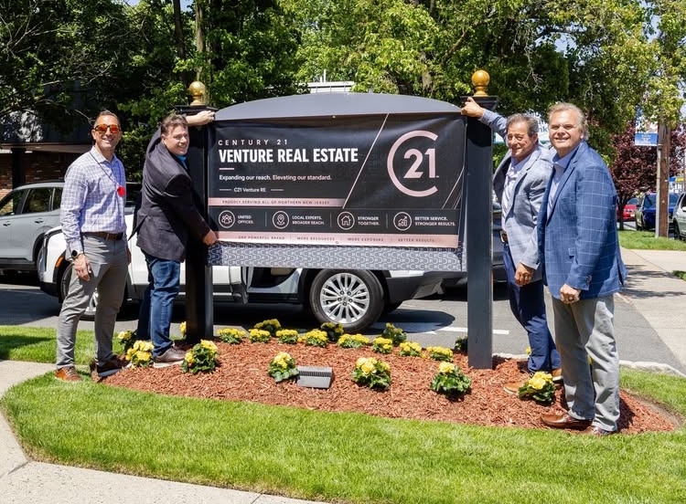 putting up Venture Real Estate sign